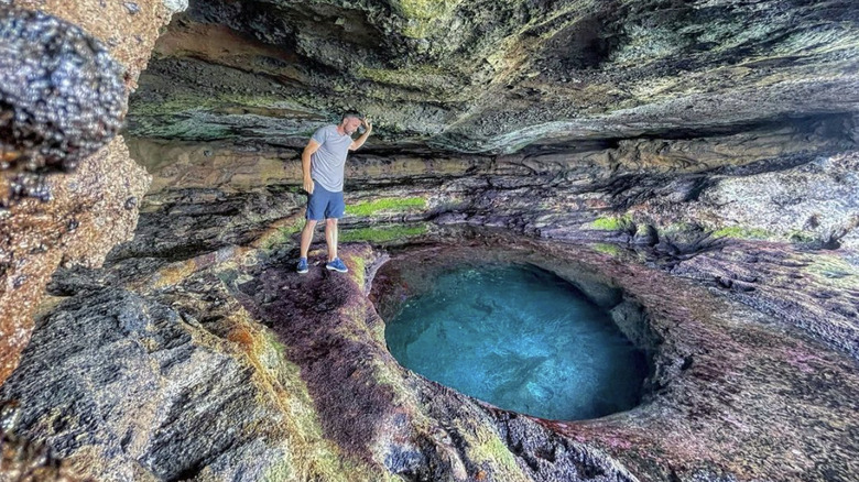 Man stands by cave
