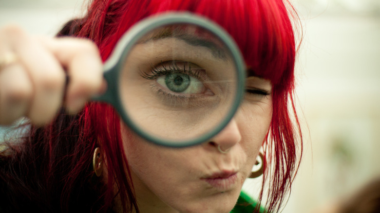 Woman looking through magnifying glass