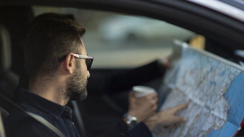 people in car looking at map