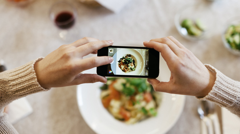 person photographing their food