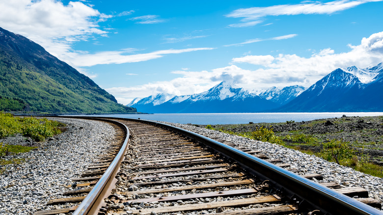 railroad tracks with mountainous backdrop