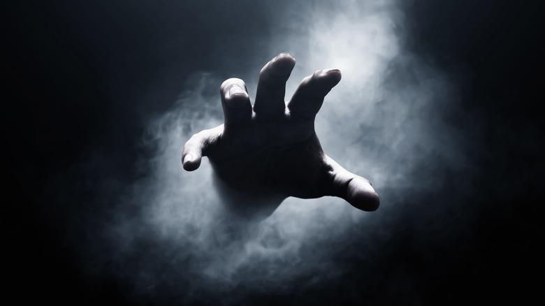 scary hand reaching from mist