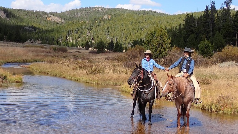 couple riding horses in Wyoming
