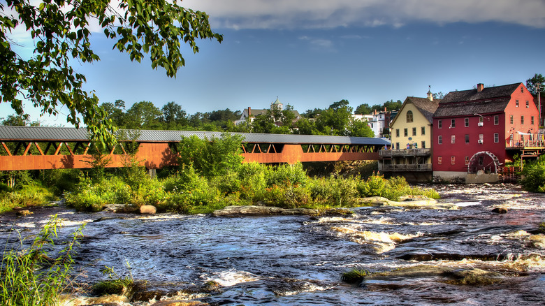 covered bridge and red building by river