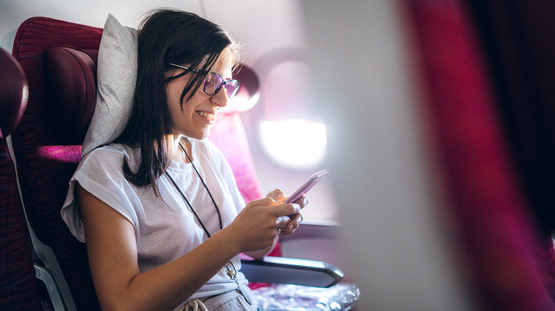 Woman using pillow on plane