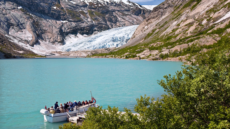 A tourist boat taking people across a lake to a glacier