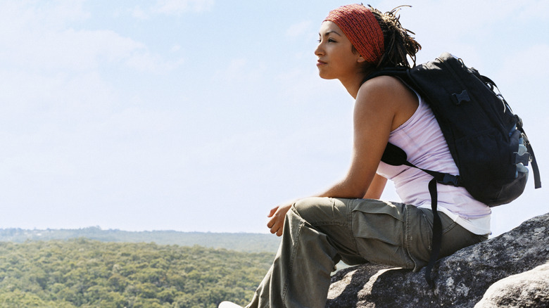 woman sitting on rock ledge 