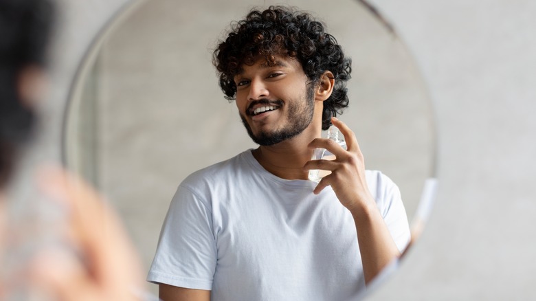 Man spraying cologne on neck