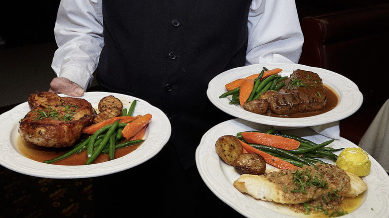 A formally-dressed waiter presents plates of meat at Fior d'Italia.