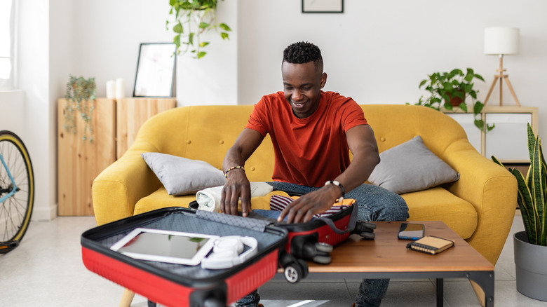 man packing suitcase