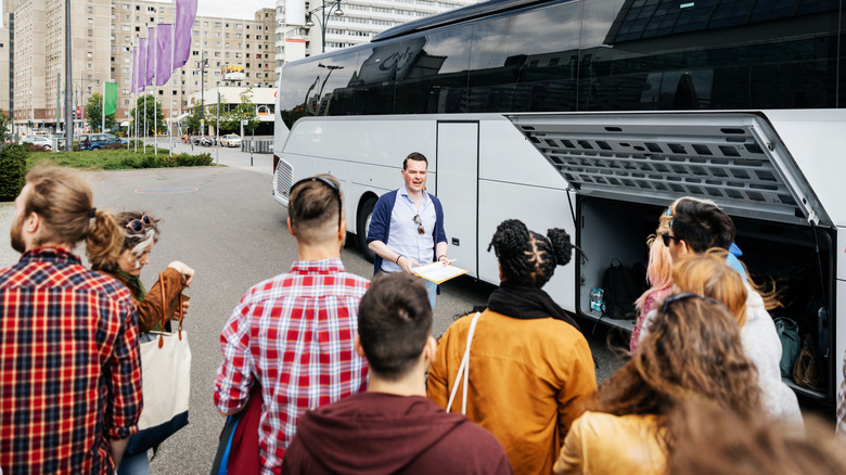 A tour group and a guide next to a bus