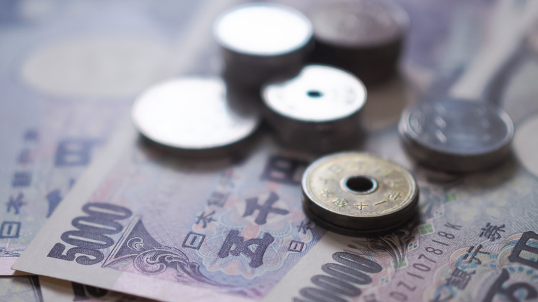 Japanese yen notes and coins reflecting the light