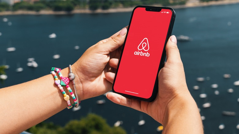 Hands holding phone on airbnb app