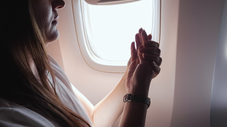 Woman on plane moisturizes hands