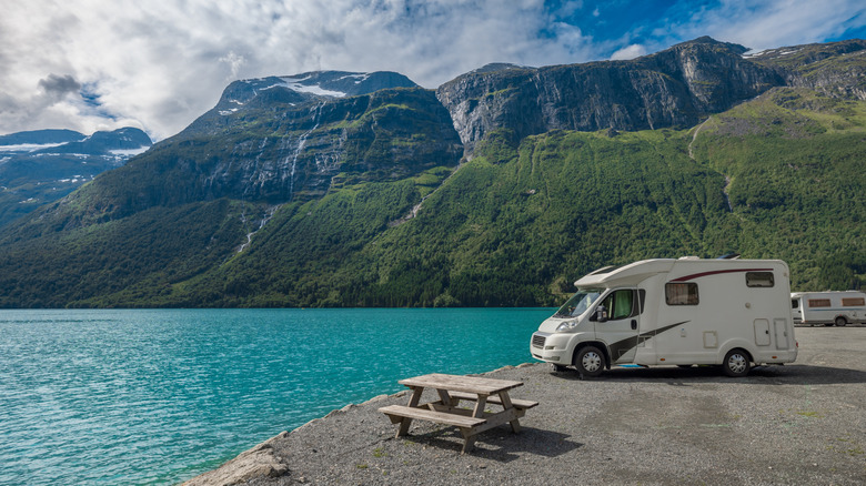 scenic view of mountains and lake with caravan at campsite