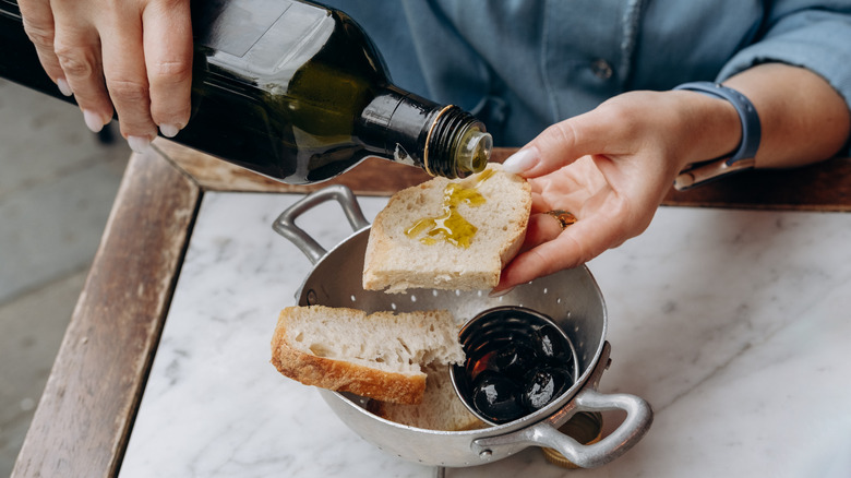 Pouring olive oil on bread