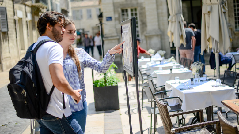 tourists reading menu in Europe