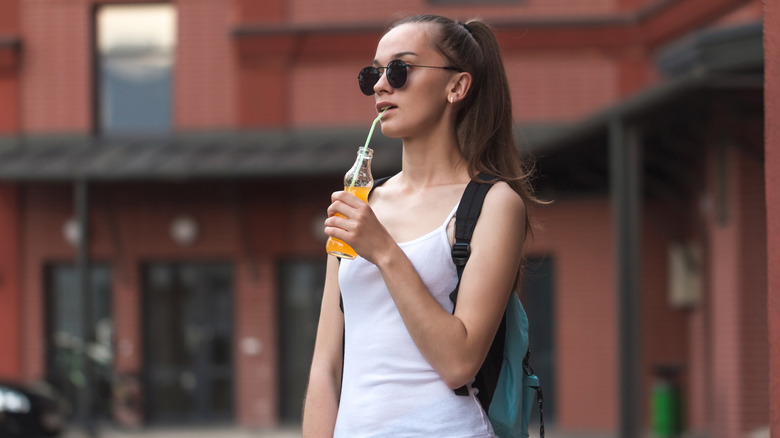 Woman drinking Fanta with straw