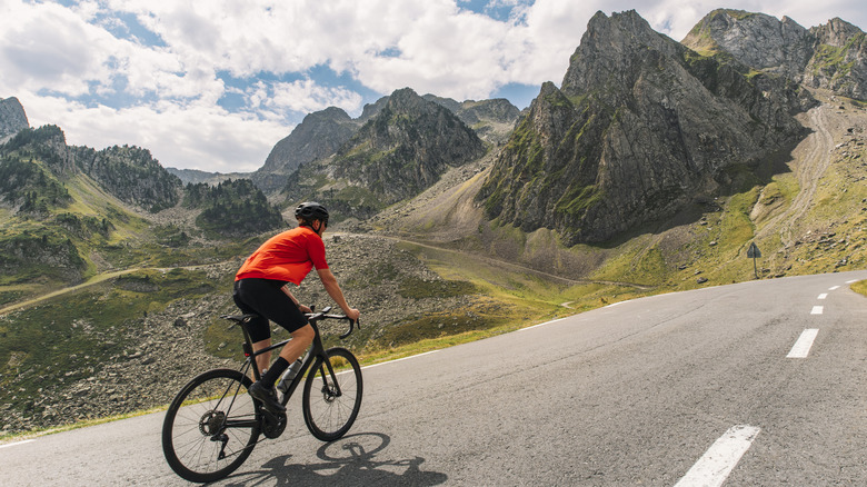 A man rides a bicycle in the mountains