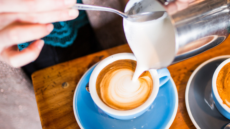 Barista pouring flat white coffee