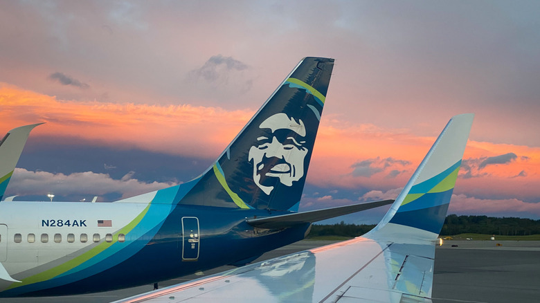 The tail and wing of two Alaska Airlines planes.