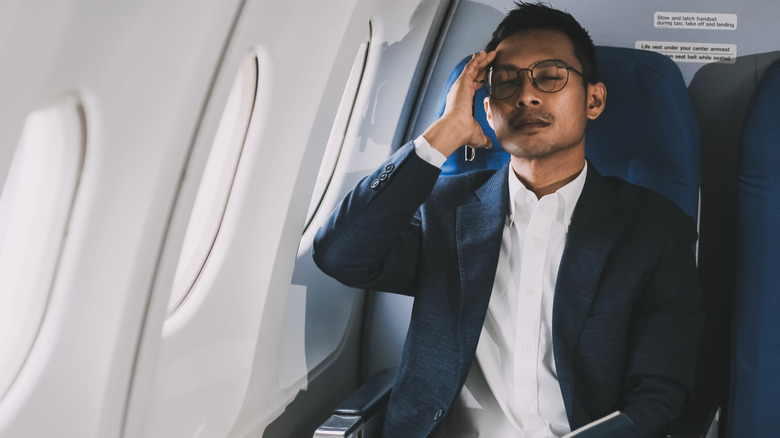 An unhappy man on an airplane.