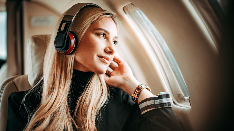 Woman wearing headphones in-flight