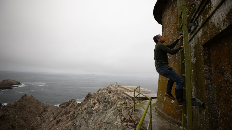 Researcher climbing up lighthouse