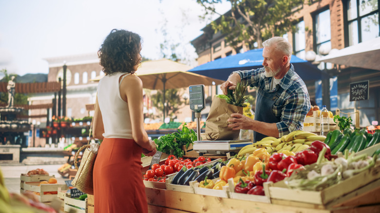 Market shopper speaking with vendor