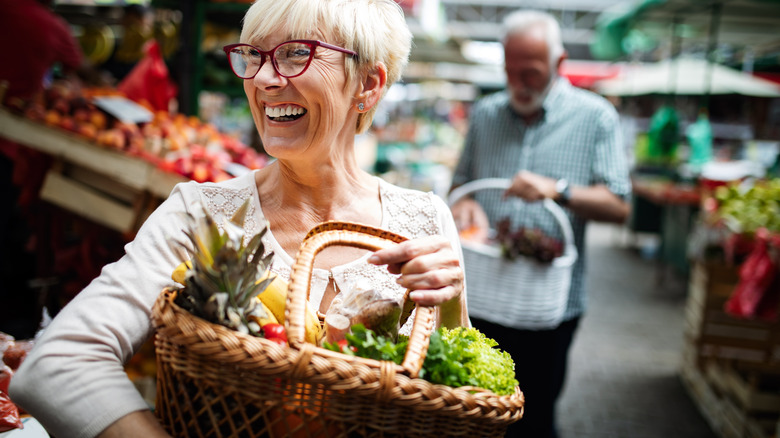 Smiling woman carrying vegetable basket