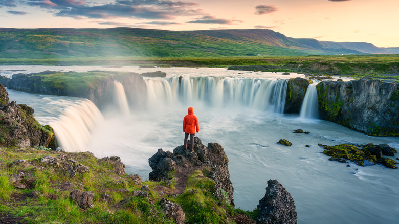 Man standing near Godafoss waterfall in Iceland