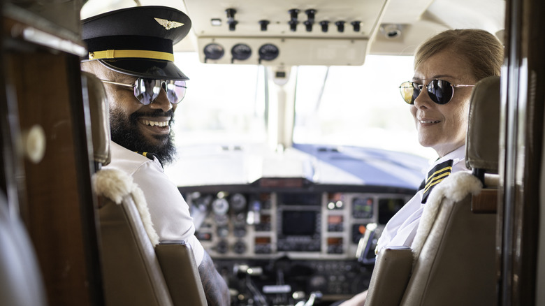 two pilots smiling in a cockpit