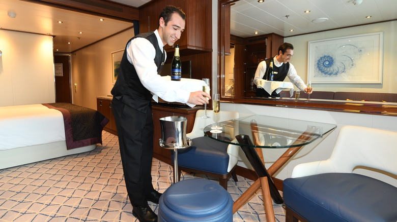 Steward places champagne in cabin
