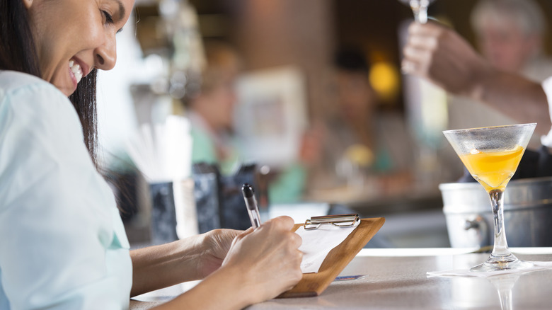 Woman signing receipt after paying tab