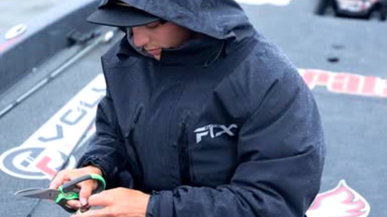 Young angler wears Frogg Toggs raincoat on boat