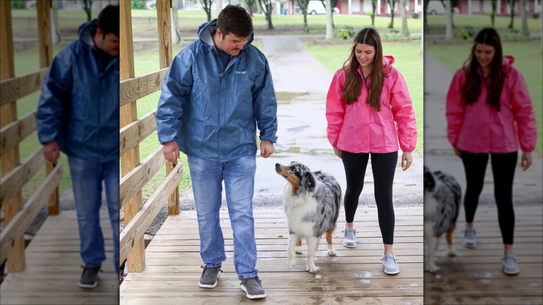 A man and woman in Frogg Toggs rain jackets with their dog.