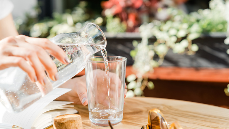 A woman pours water from a decanter