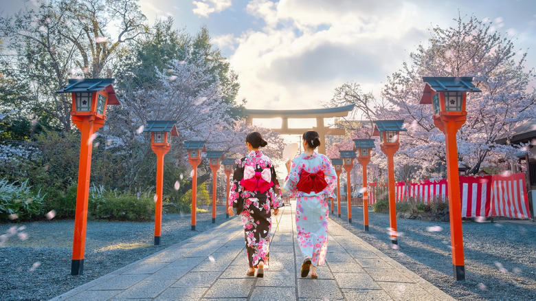 two women walking by a shrine