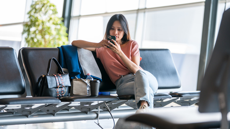 Woman using phone at airport