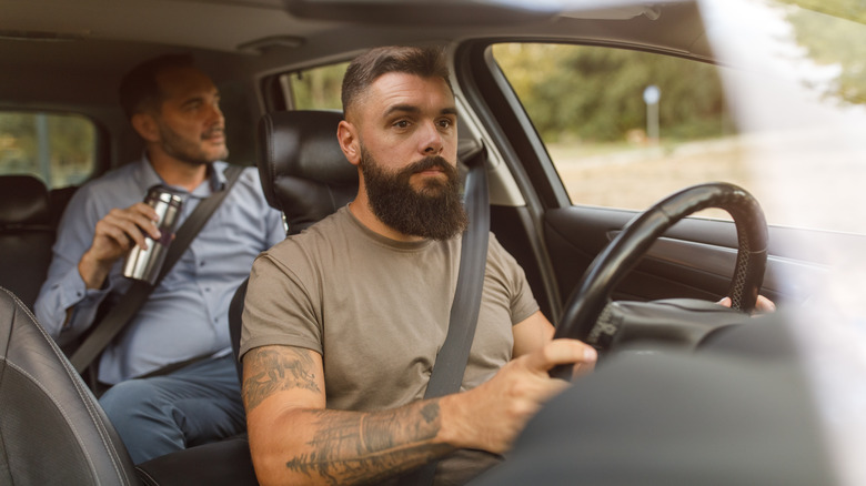 man driving passenger in car