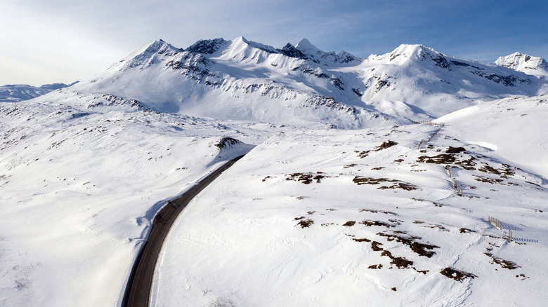 highway leading through snowy mountains