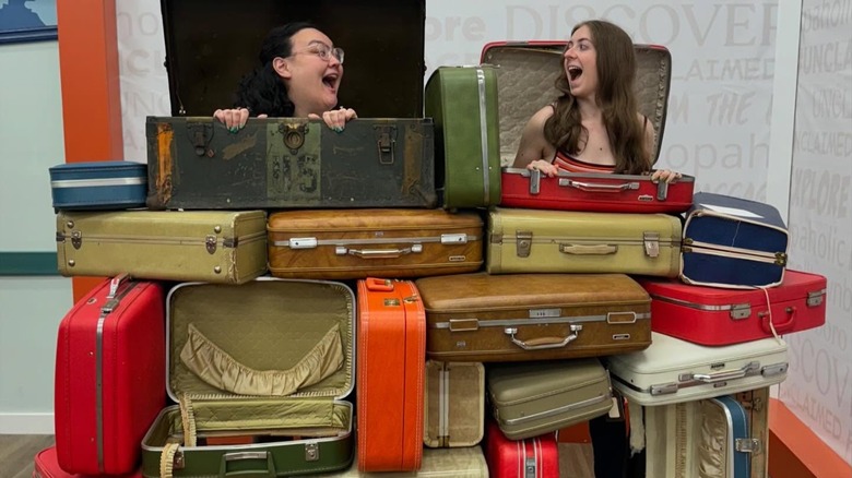 Two girls posing at the luggage stand at Unclaimed Luggage store