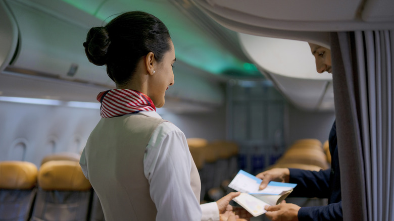 Flight attendant assisting a passenger