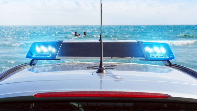 police car next to ocean