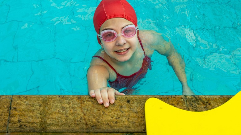 Child in pool wearing swimming cap