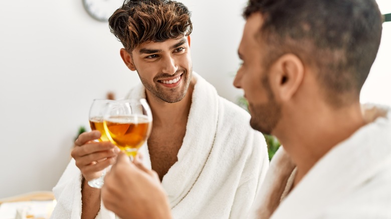 Couple toasting in spa bathrobes