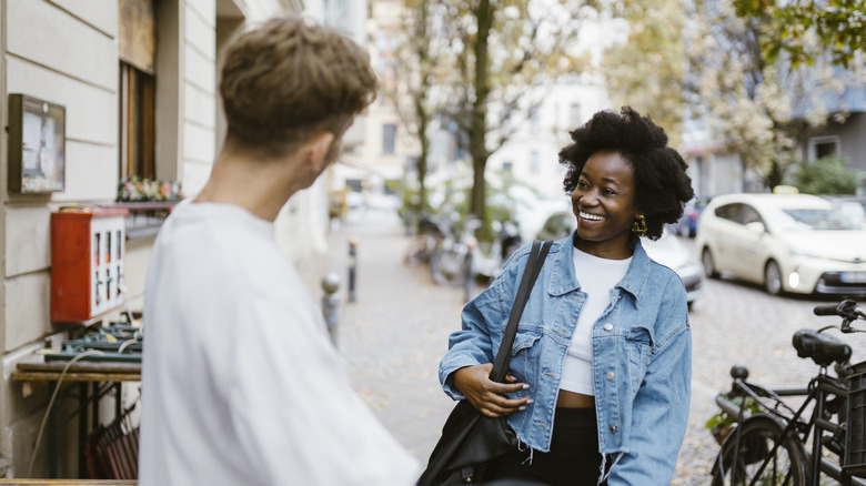 Woman smiling at man on the street