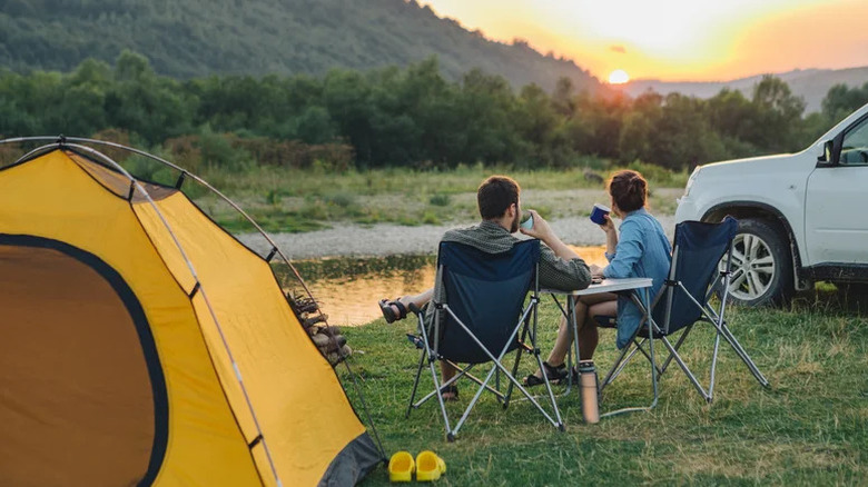 couple camping tent suv sunset