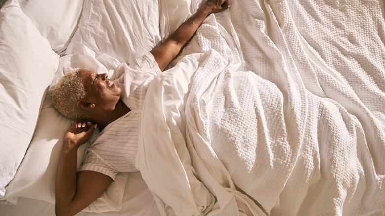 Traveler waking up in hotel bed