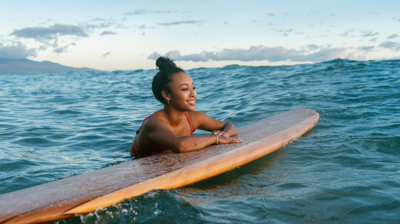 Smiling woman with surfboard